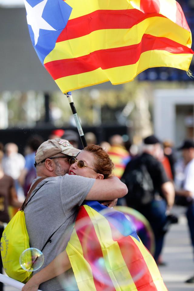  A couple with Catalonian flag hug each other near the Arc de Triomf close to Catalonia's regional assembly