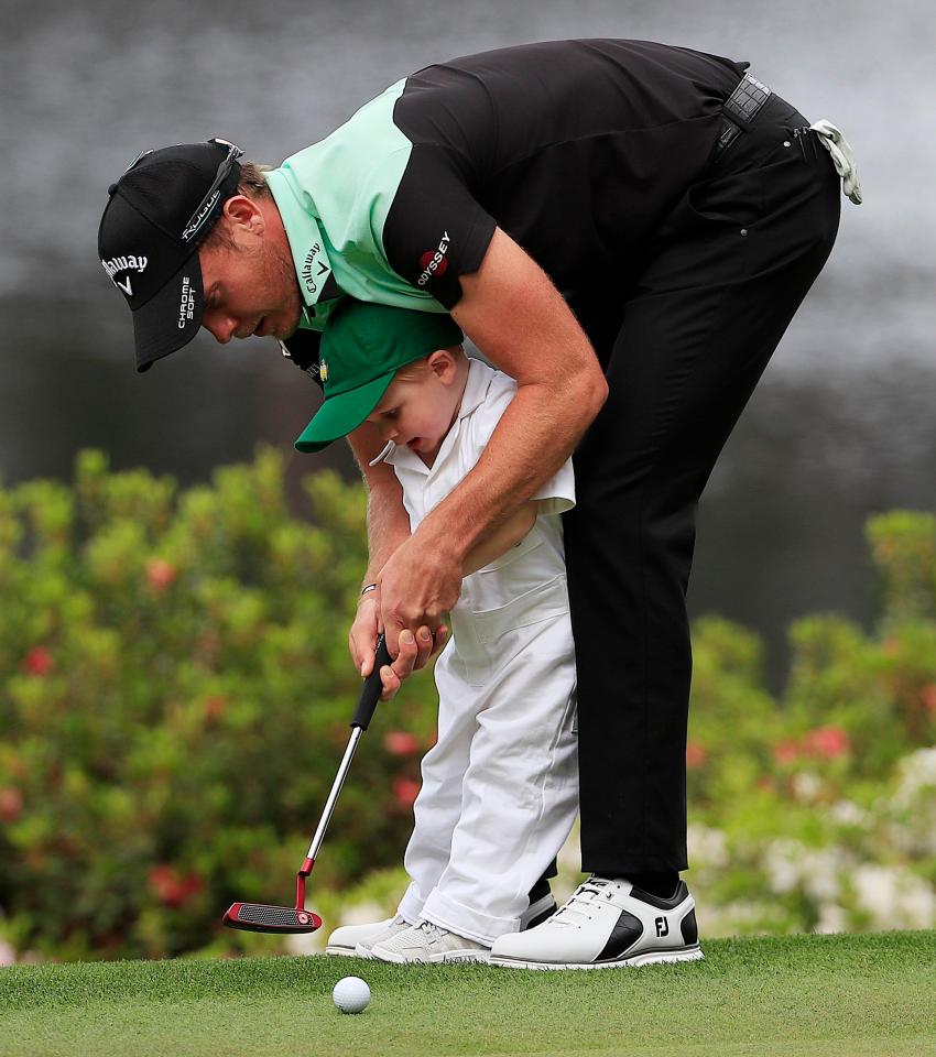  Former champion Danny Willett helps his son Zachariah putt on the fifth hole