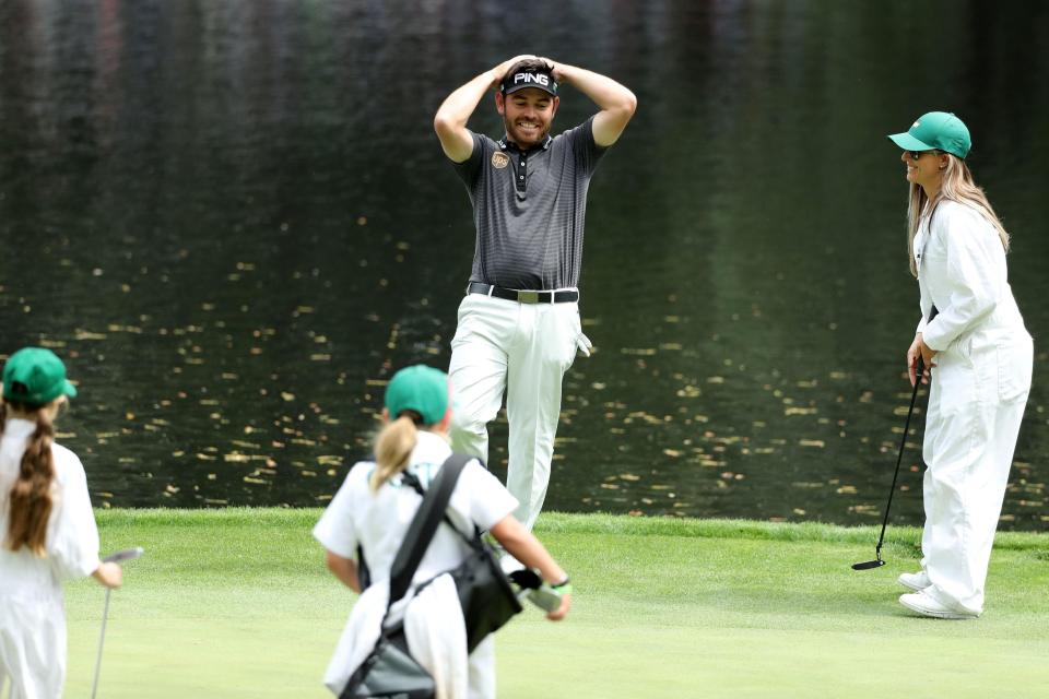 Louis Oosthuizen of South Africa reacts to his wife's putt on the 9th hole