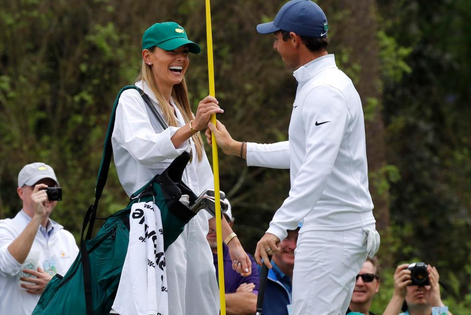  Rory McIlroy of Northern Ireland hands a pin marker to his wife Erica Stoll