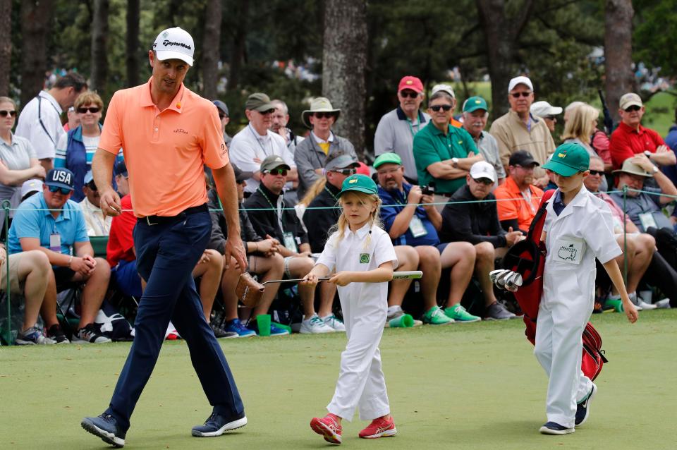  Justin Rose of England walks off the first green with his two children