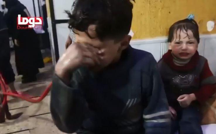  A young boy wipes his eyes after the alleged chemical attack