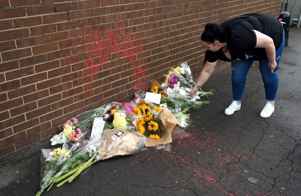  Floral tributes were left at the scene where Mr Cash was filmed being covered in red paint
