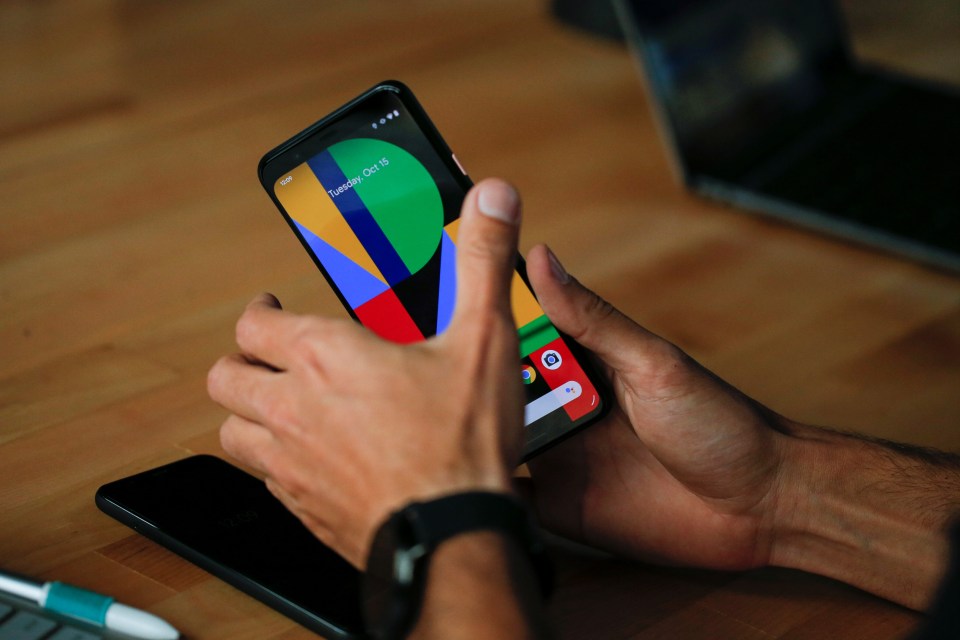 Person holding and looking at a Google Pixel 4 smartphone.