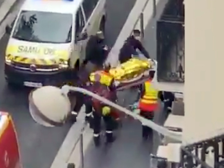 Paramedics place a victim on a stretcher outside the church 