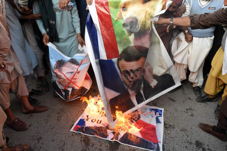 Muslims burn posters with the picture of French President Emmanuel Macron in Quetta, Pakistan