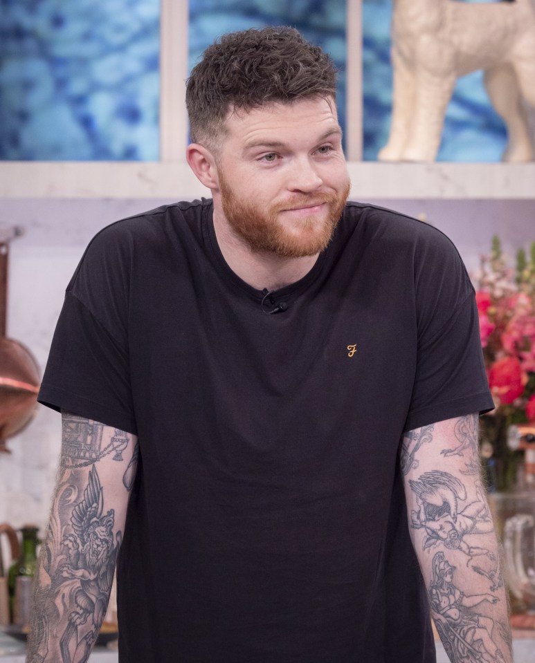 a man with a beard is wearing a black shirt with the letter f on it