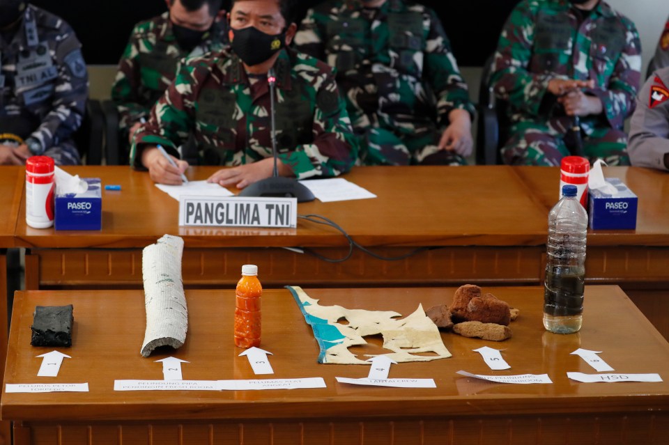 A military officer displays debris believed to be from a missing Indonesian Navy submarine KRI Nanggala