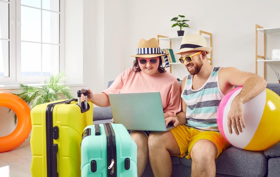 Couple using laptop to book summer vacation.