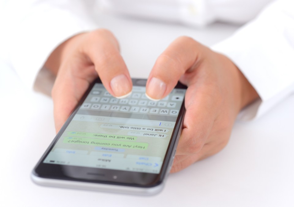 Hands holding an iPhone and texting.
