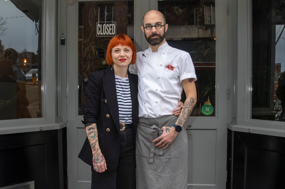 a man and a woman stand in front of a closed door