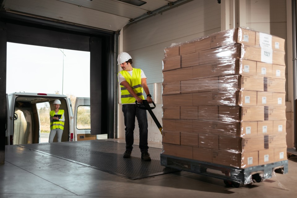 a man is loading boxes on a pallet with a label that says t321