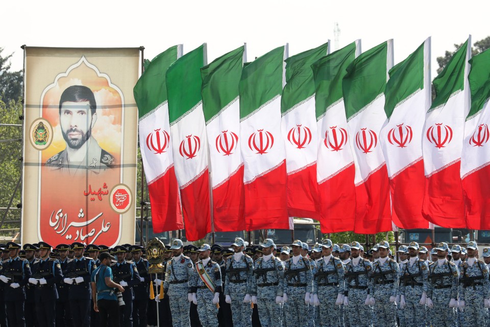 Iranian soldiers line up under flags to mark the country’s annual army day