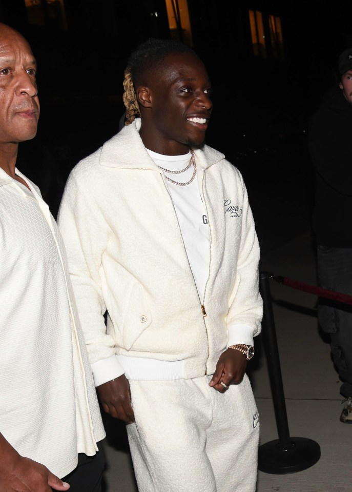 A cheery Jeremy Doku in an a smart all-white outfit for the evening