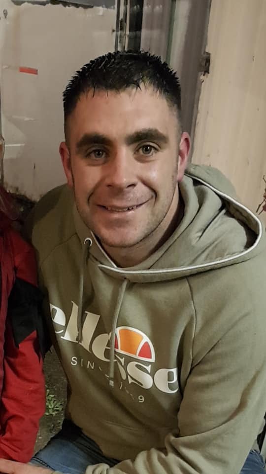 a man wearing an ellesse sweatshirt smiles for the camera