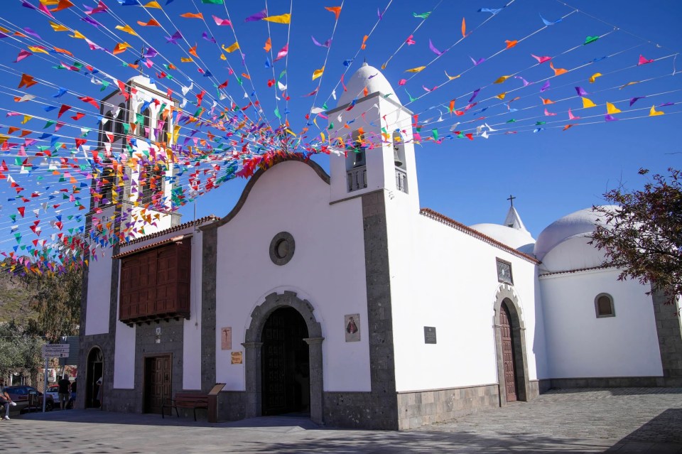a church is decorated with colorful flags on a sunny day