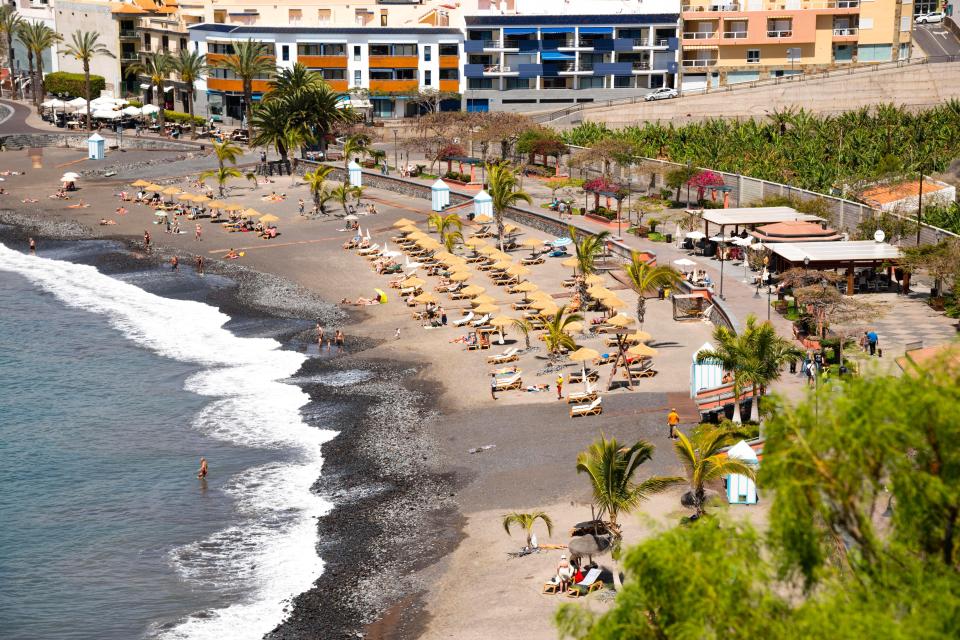 a beach with a lot of umbrellas and chairs
