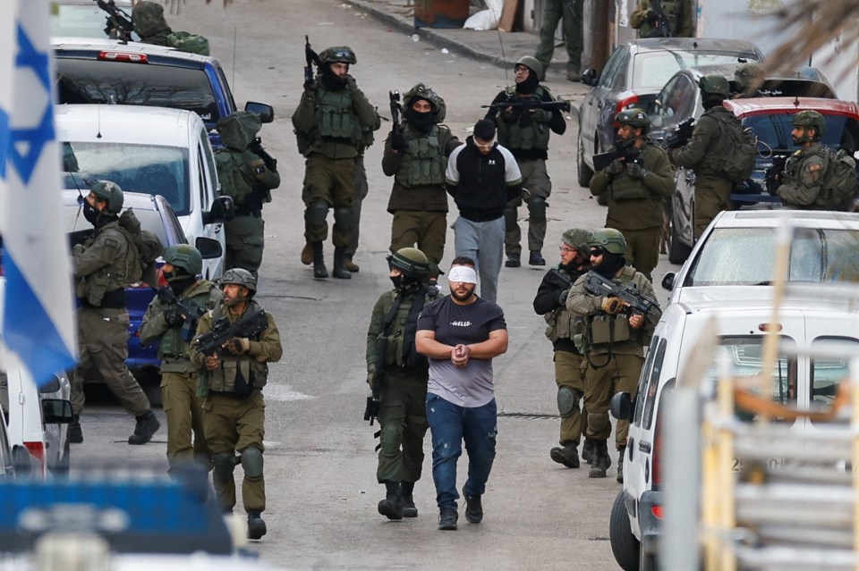 Israeli soldiers detain Palestinians during a raid, in Ramallah, in the Israeli-occupied West Bank March 4, 2024. REUTERS/Mohammed Torokman