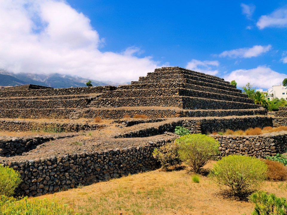 a stone pyramid with a blue sky in the background