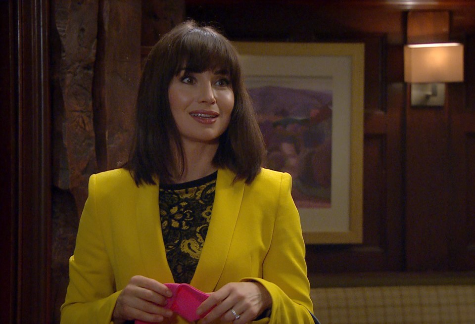 a woman in a yellow jacket holds a pink purse