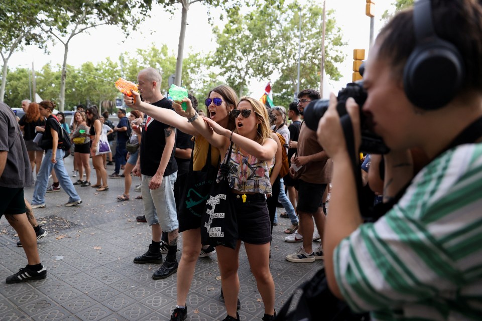 Protesters shoot water from water guns at tourists during a protest against mass tourism in Barcelona