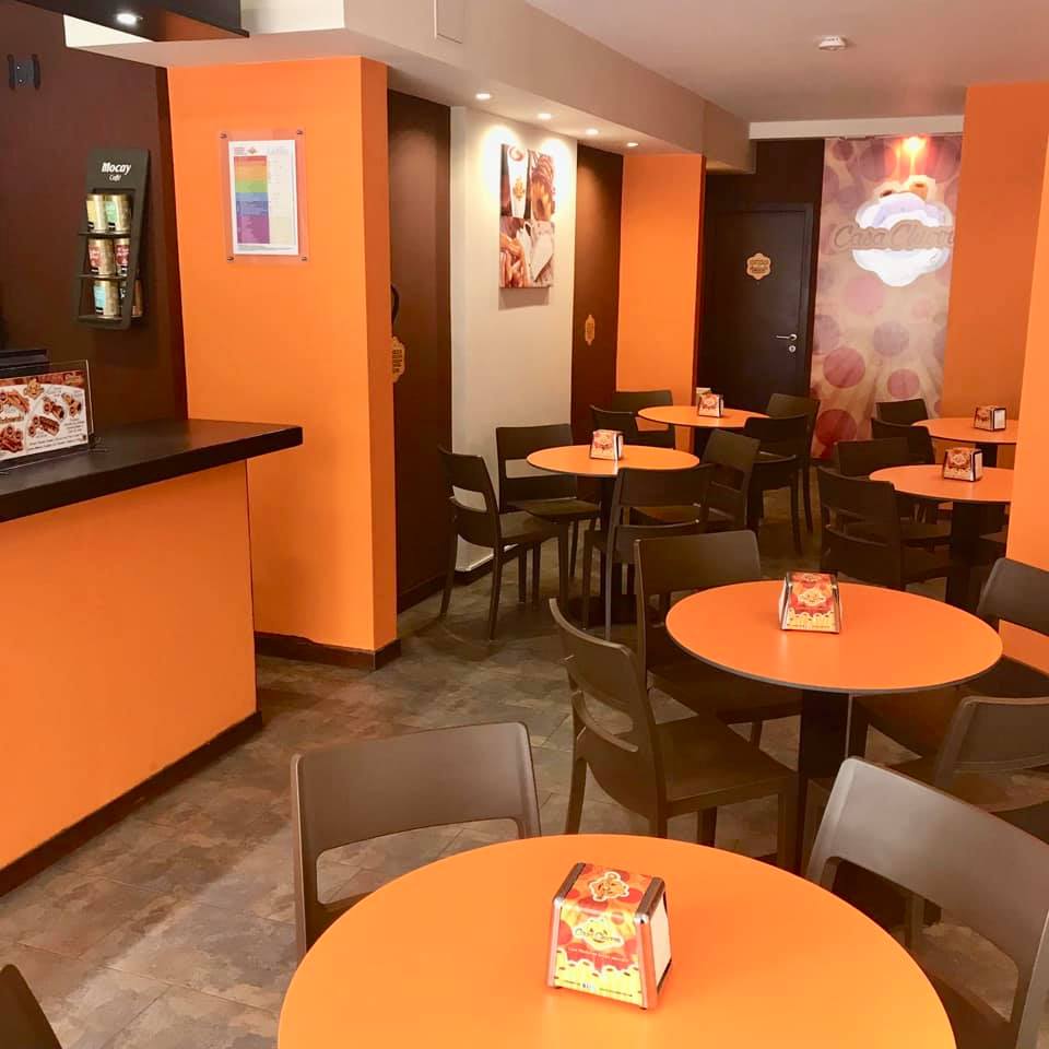 the inside of a restaurant with orange walls and tables