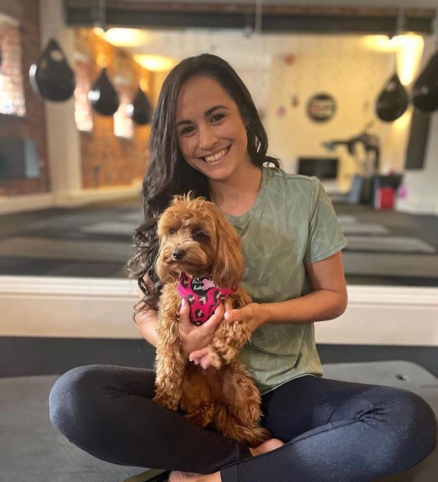 a woman is holding a small brown dog with a pink harness that says i love you