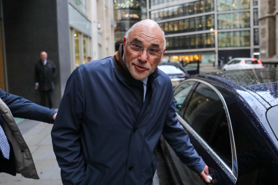 a bald man wearing glasses is getting out of a car
