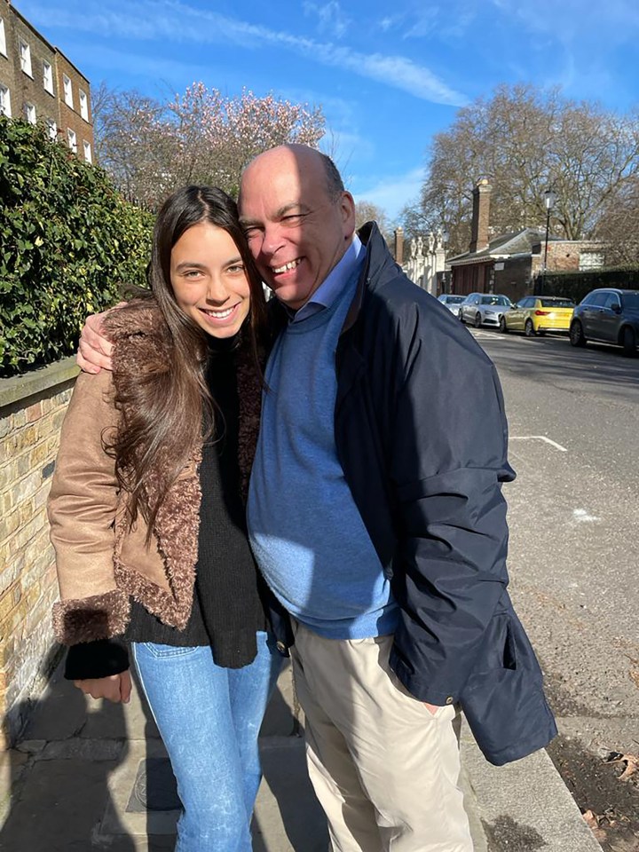 a man and a woman are posing for a picture on a sidewalk