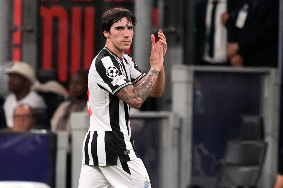 a soccer player with a tattoo on his arm applauds the crowd