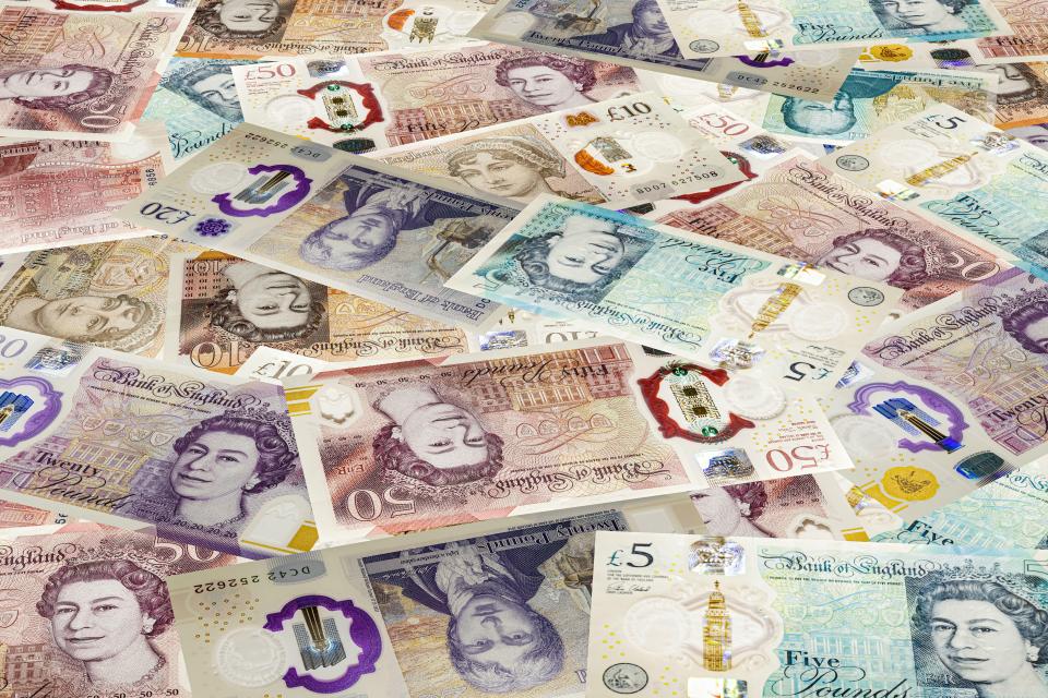 a pile of british currency including five pounds