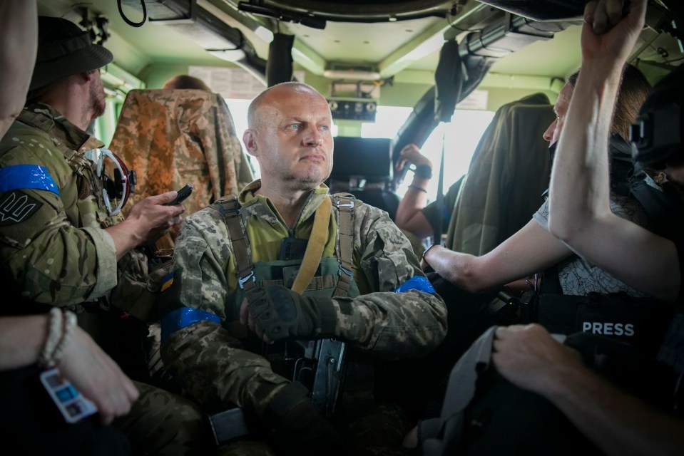 a man in a military uniform is being interviewed by a press reporter
