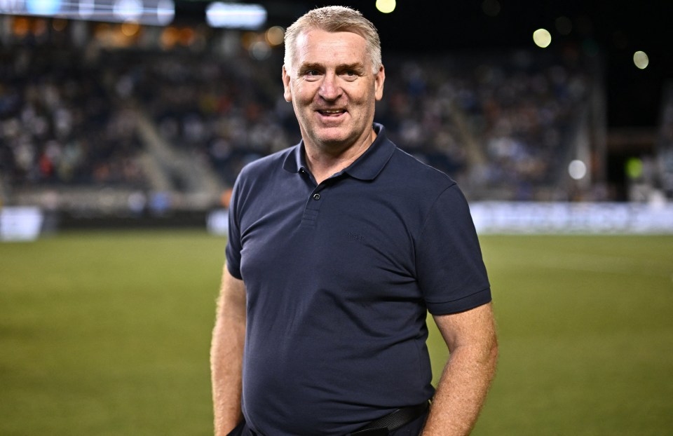 a man in a blue shirt stands on a soccer field