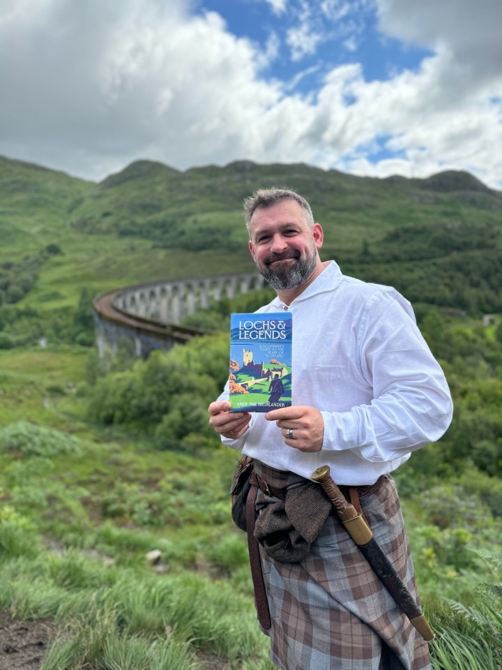 a man in a kilt is holding a book titled lochs & legends