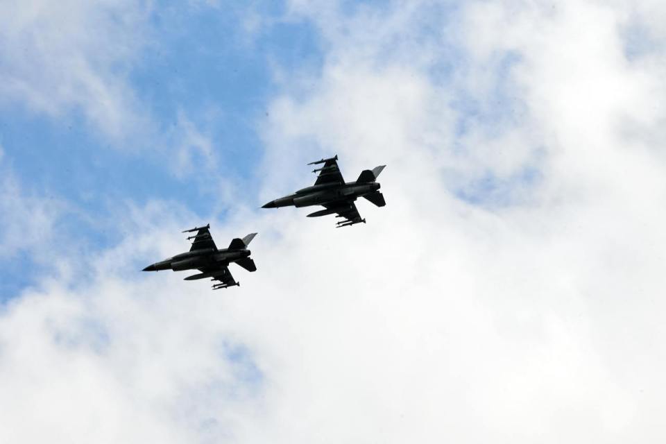 two fighter jets are flying side by side in the sky