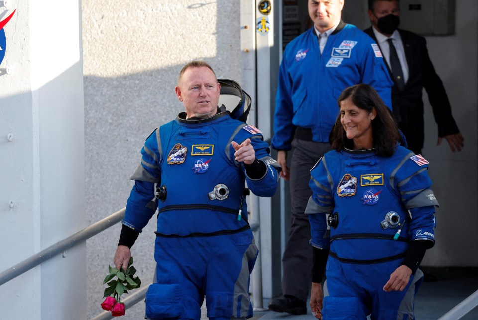 a group of nasa astronauts are walking down a hallway