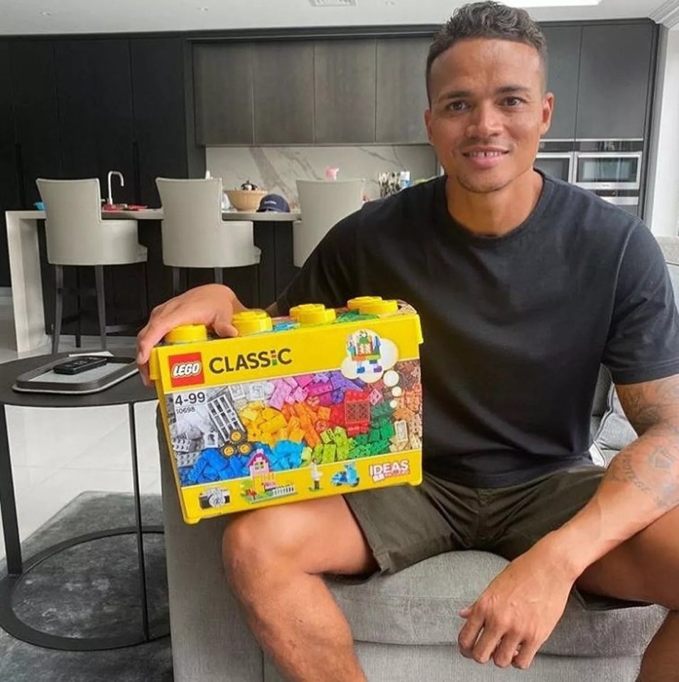 a man is holding a box of lego classic bricks