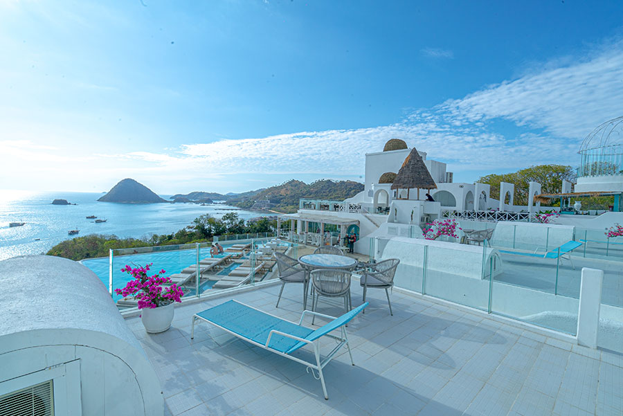 a balcony with a table and chairs overlooking the ocean