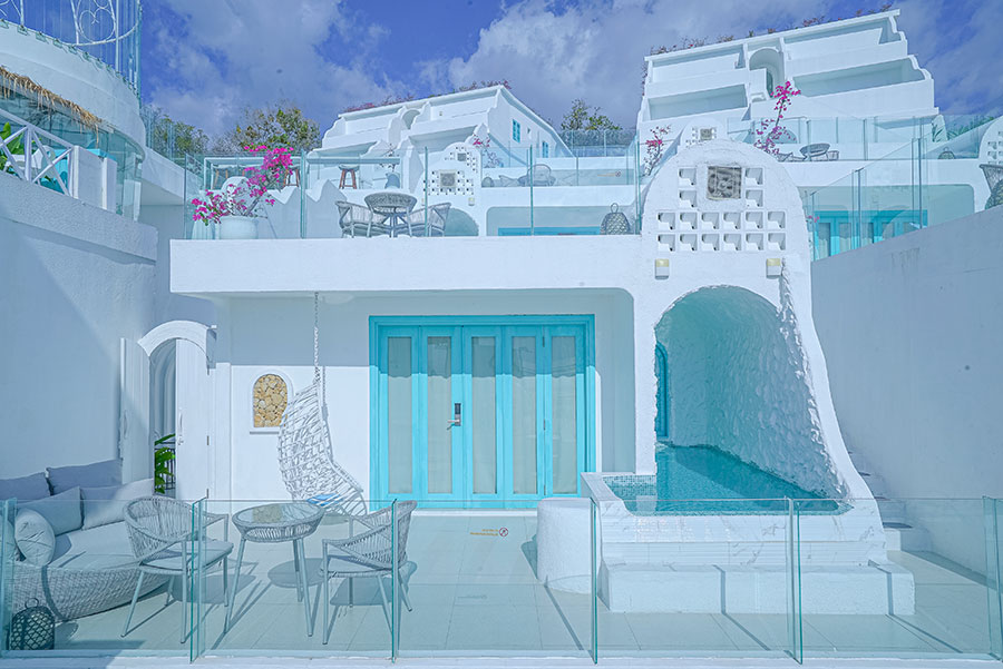 a white house with a blue door and a swimming pool