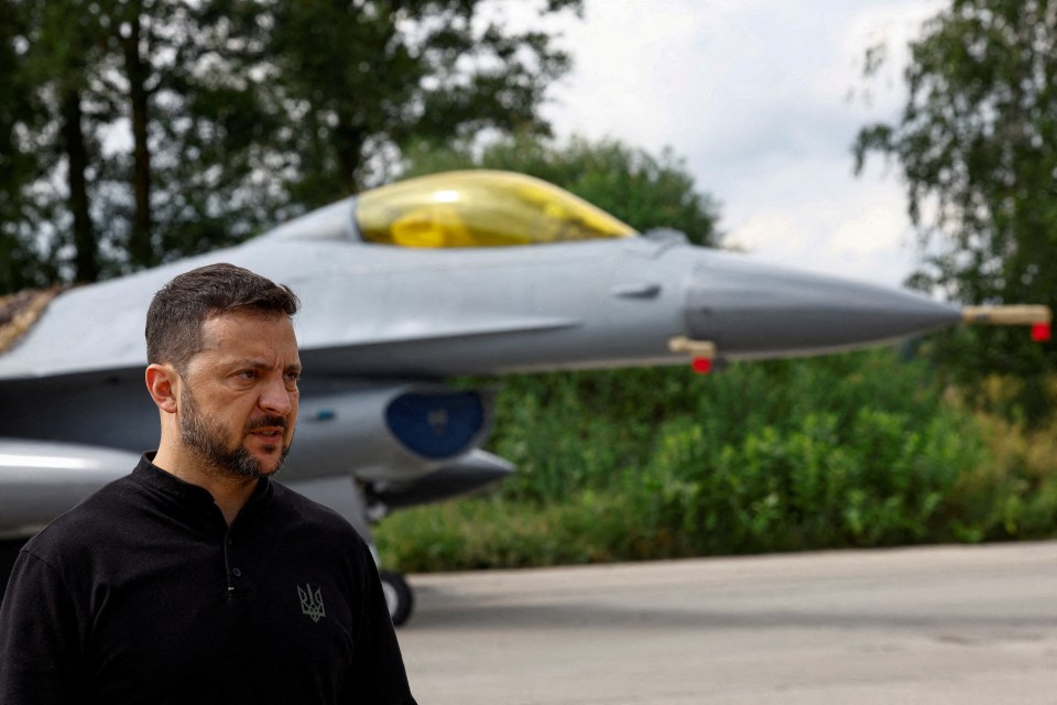 a man stands in front of a fighter jet with a yellow cockpit