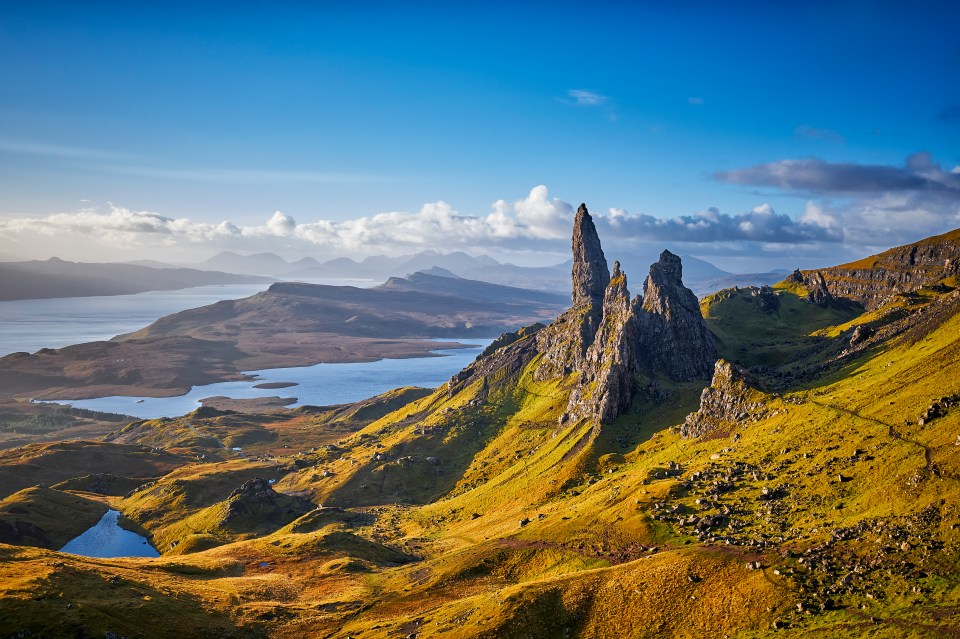 a mountain with a lake and mountains in the background