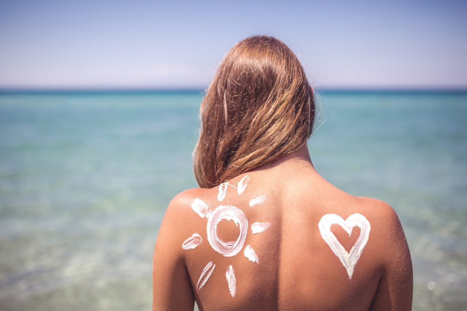 a woman has a sun and a heart drawn on her back