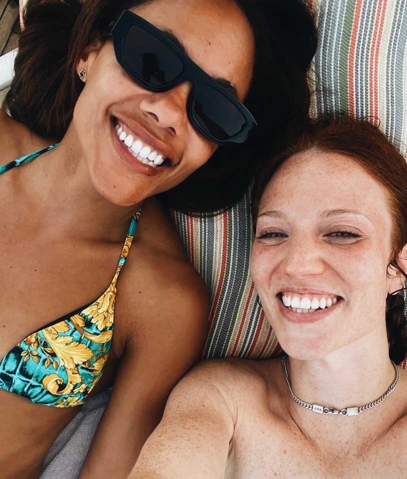 a woman in a bikini is smiling next to another woman