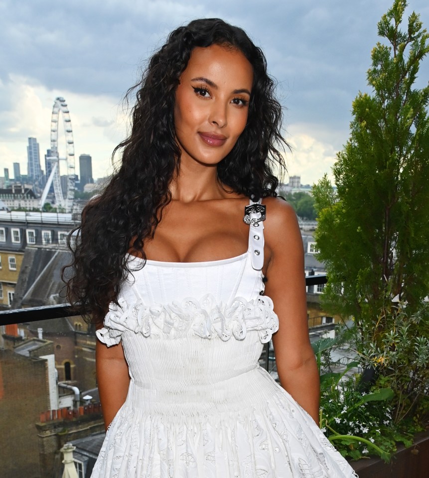 a woman in a white dress stands on a balcony overlooking a city