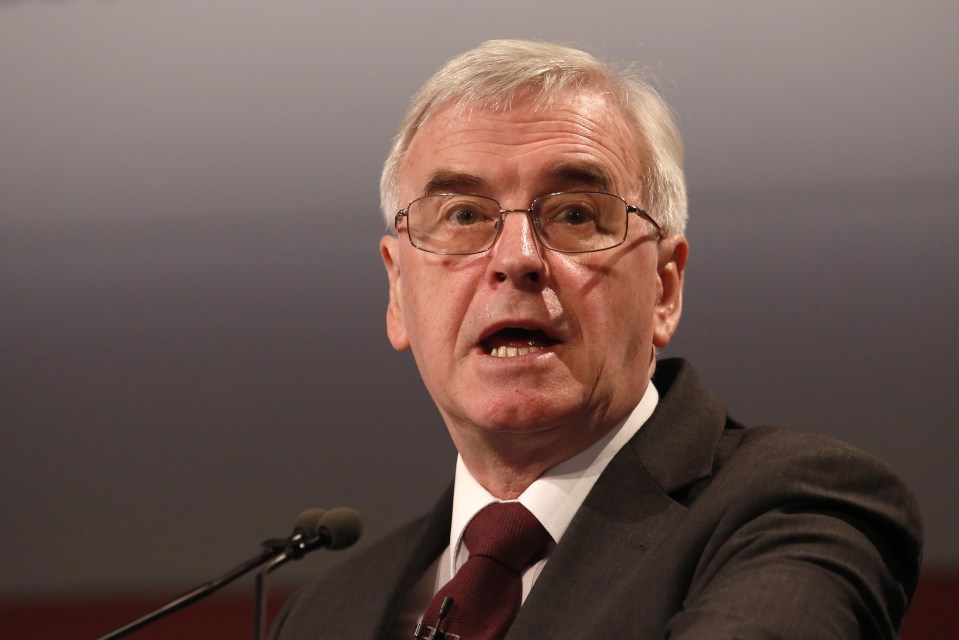 a man in a suit and tie is speaking into a microphone