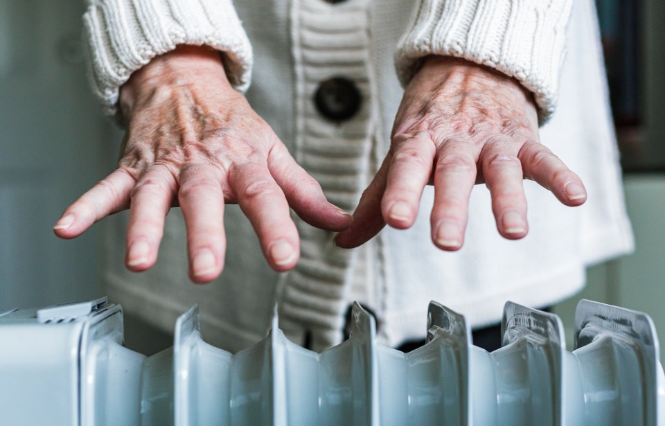 a woman 's hands are reaching out to touch a radiator