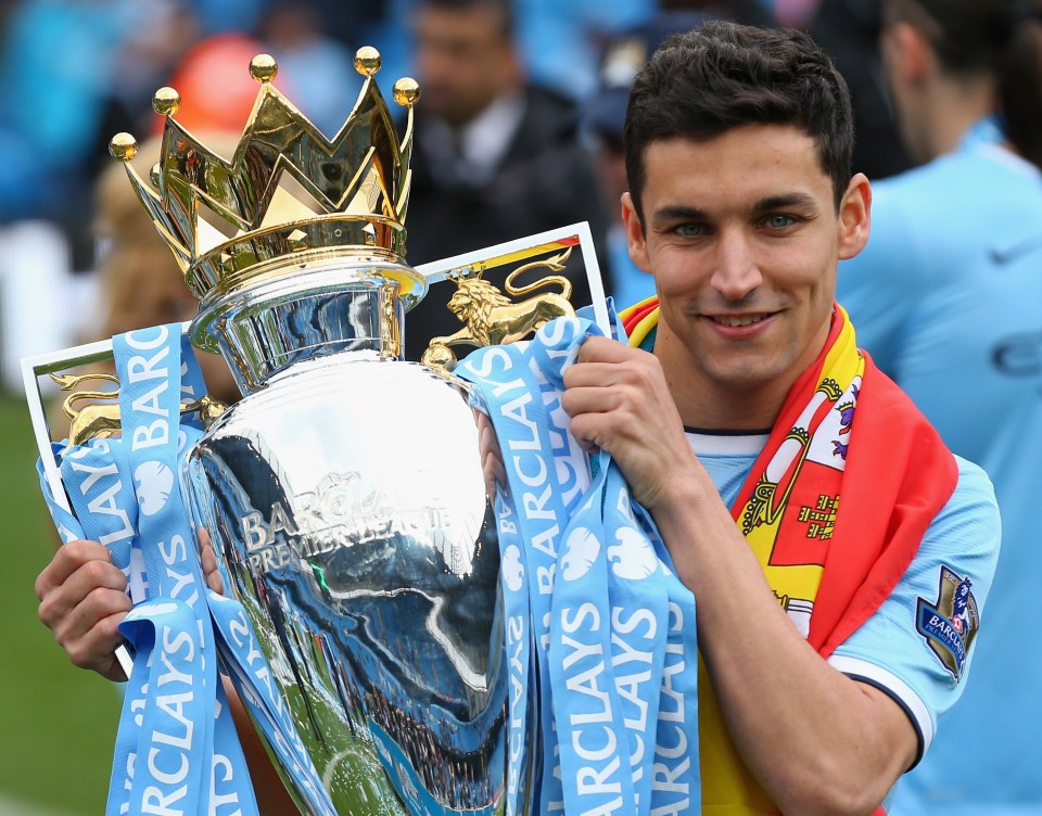 a man holding a trophy with barclays ribbons around his neck