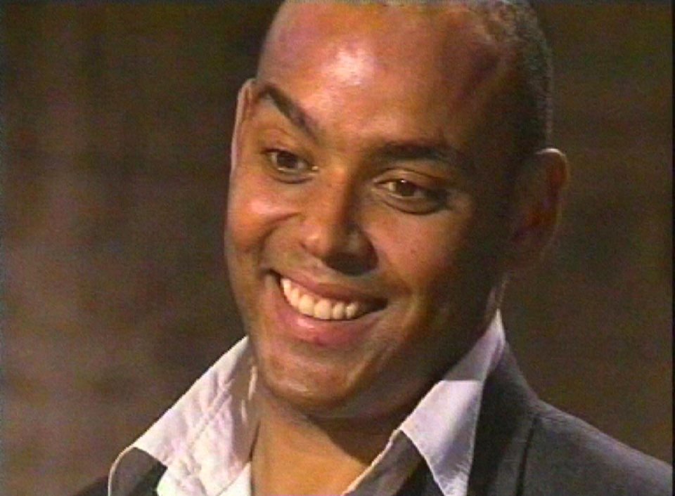 a man in a suit and white shirt is smiling