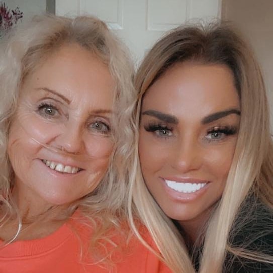 two women are posing for a picture together and smiling for the camera .