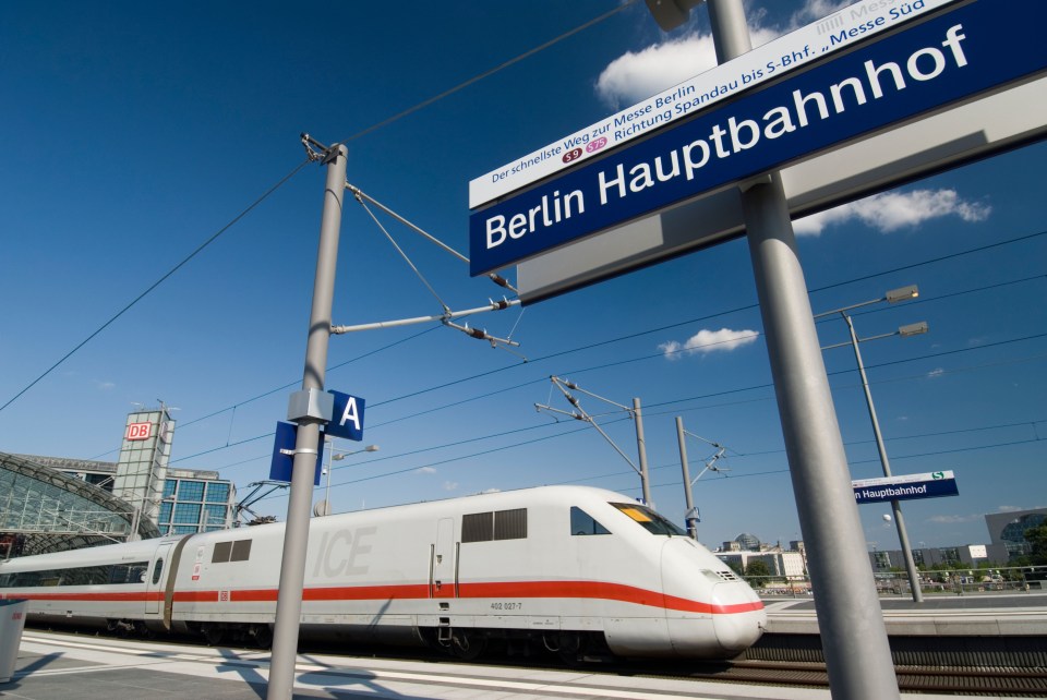 a berlin hauptbahnhof sign with a train in the background